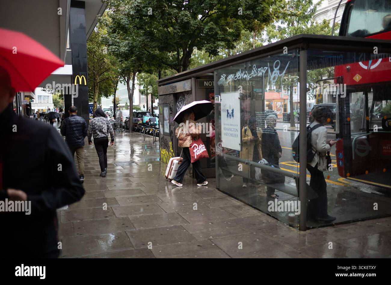 Bei starken Regenschauern im Herbst werden Pendler und Touristen am Nachmittag in Notting Hill, West london, England, Großbritannien, beobachtet Stockfoto