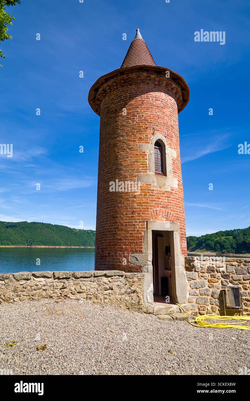 Eigenständiger Turm von Château de Val mit roten Ziegelmauern, Teil der Burgbefestigung. Stockfoto