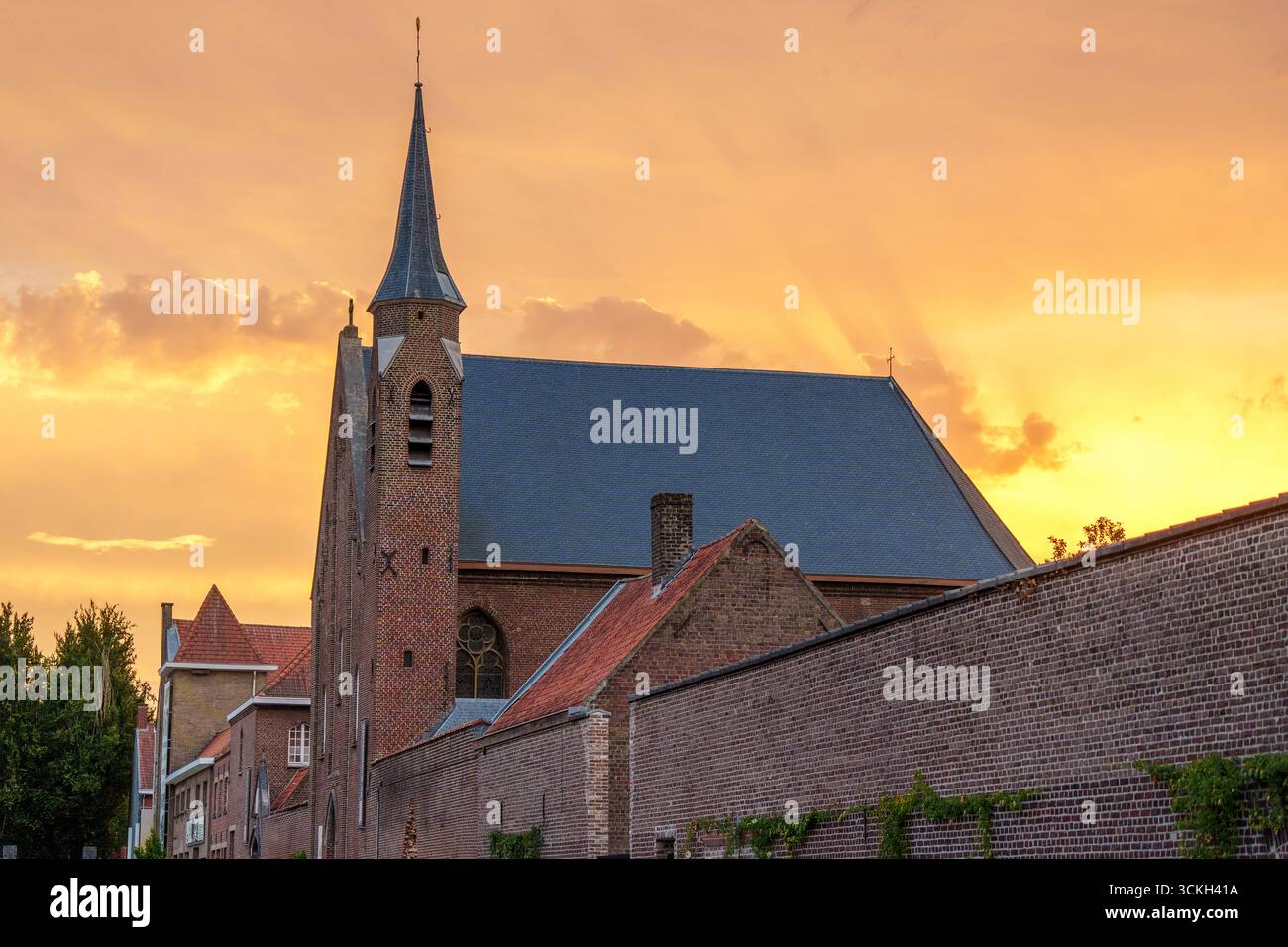 Historische ehemalige Kirche mit Ziegelmauern bei Sonnenuntergang Stockfoto