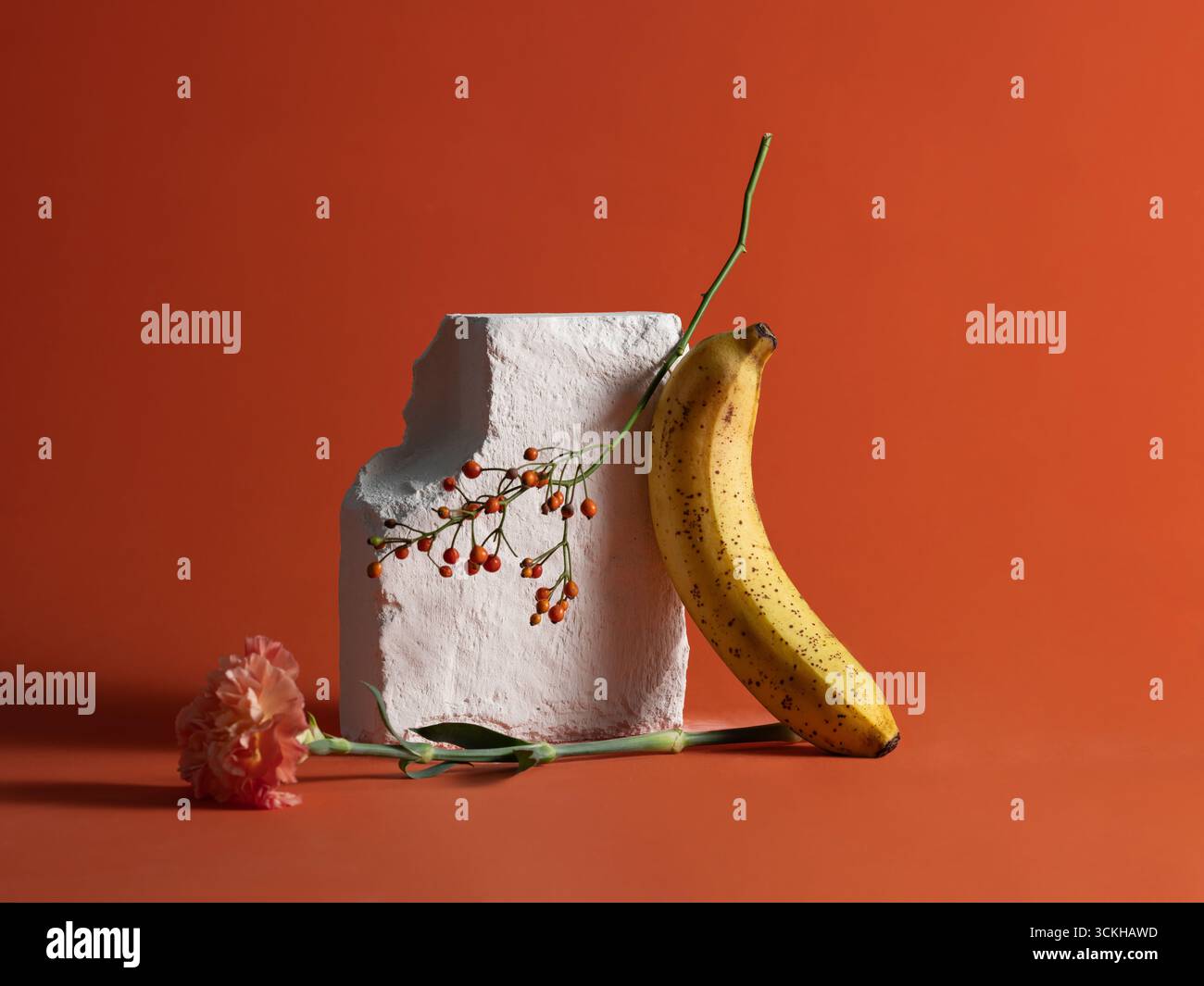 Ein stilvolles Stillleben mit reifer Banane, Blume und Beeren Stockfoto