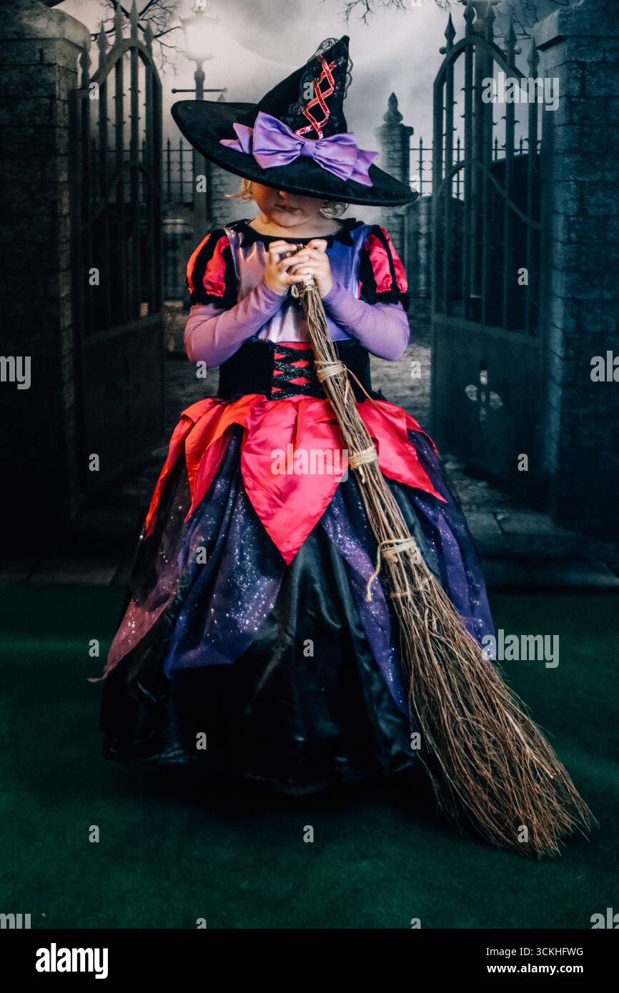 Halloween Kind Hexe hält einen Besenstiel Stockfoto