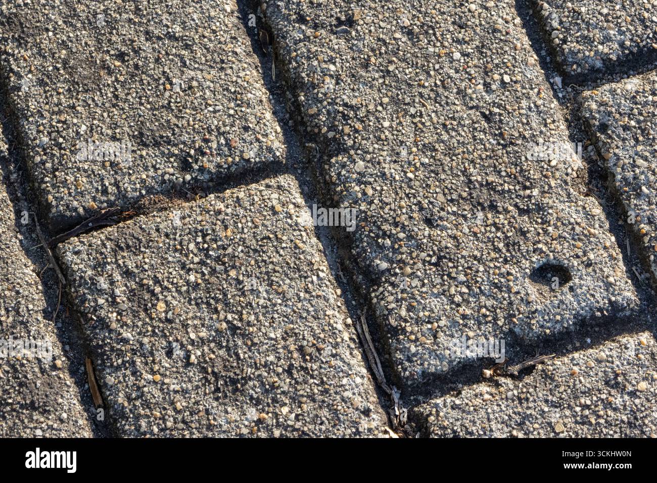 Detaillierte Ansicht einer strukturierten Betonpflasteroberfläche, die das Material und die Konstruktion des Zuschlagstoffs hervorhebt Stockfoto