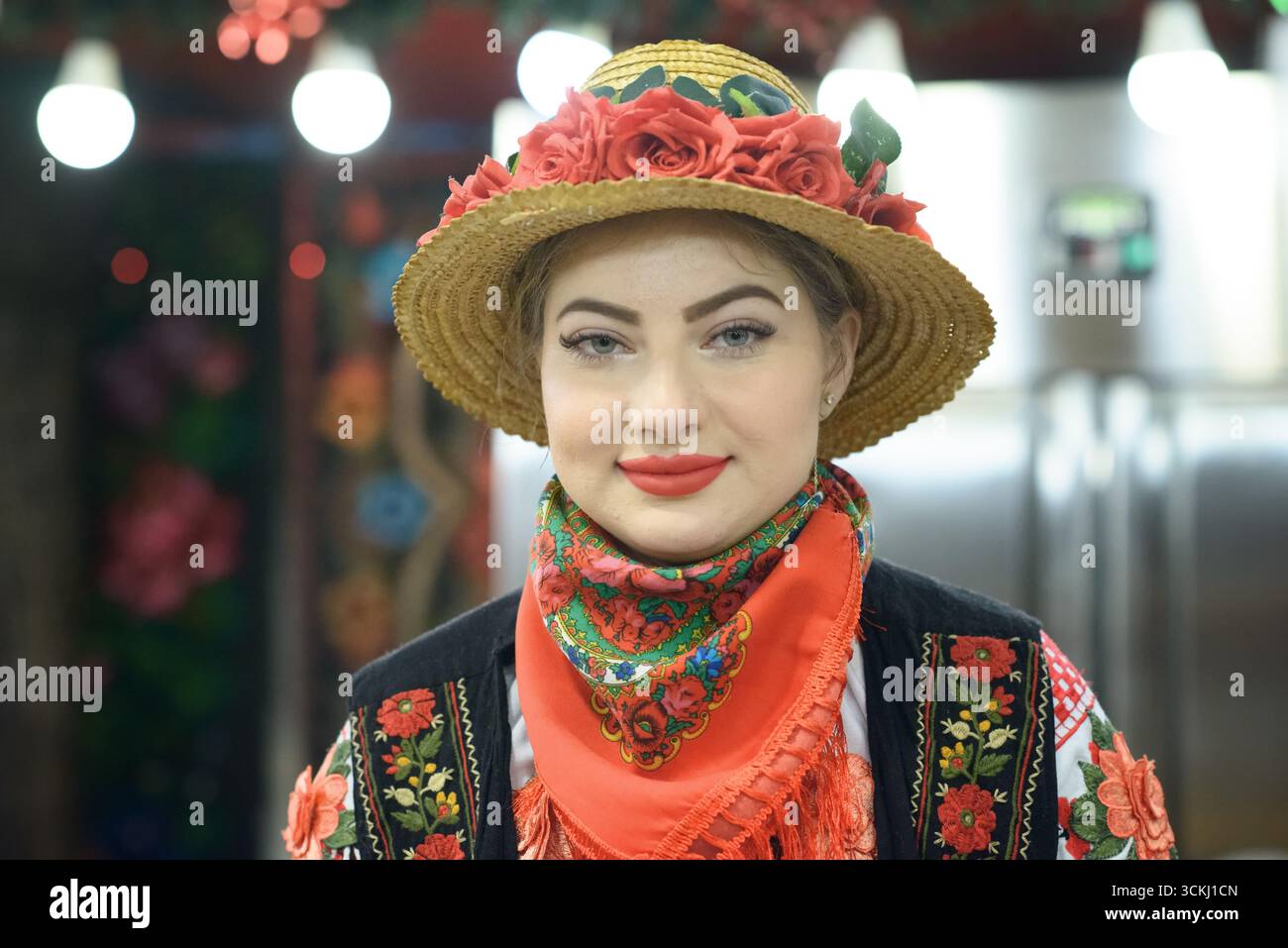Junge Frau in traditioneller festlicher Kleidung während einer kulturellen Feier auf dem Weihnachtsmarkt in Craiova, Rumänien. Stockfoto