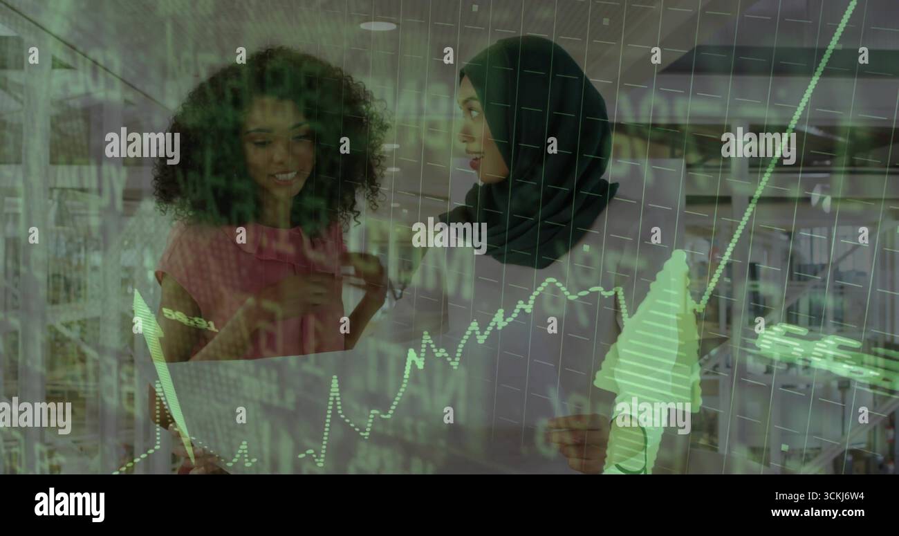 Untersuchung von Frauen in Bluse und Schal, die im Büro mit Eingabestift-Diagrammen auf eine klare digitale Anzeige zeigen Stockfoto