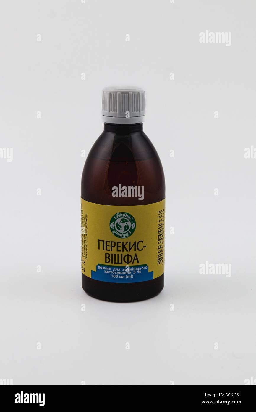 Ukraine Lviv 15.08.25 Eine braune Flasche mit Wasserstoffperoxid steht auf weißem Hintergrund. Die gelbe Beschriftung zeigt Text in einer anderen la Stockfoto