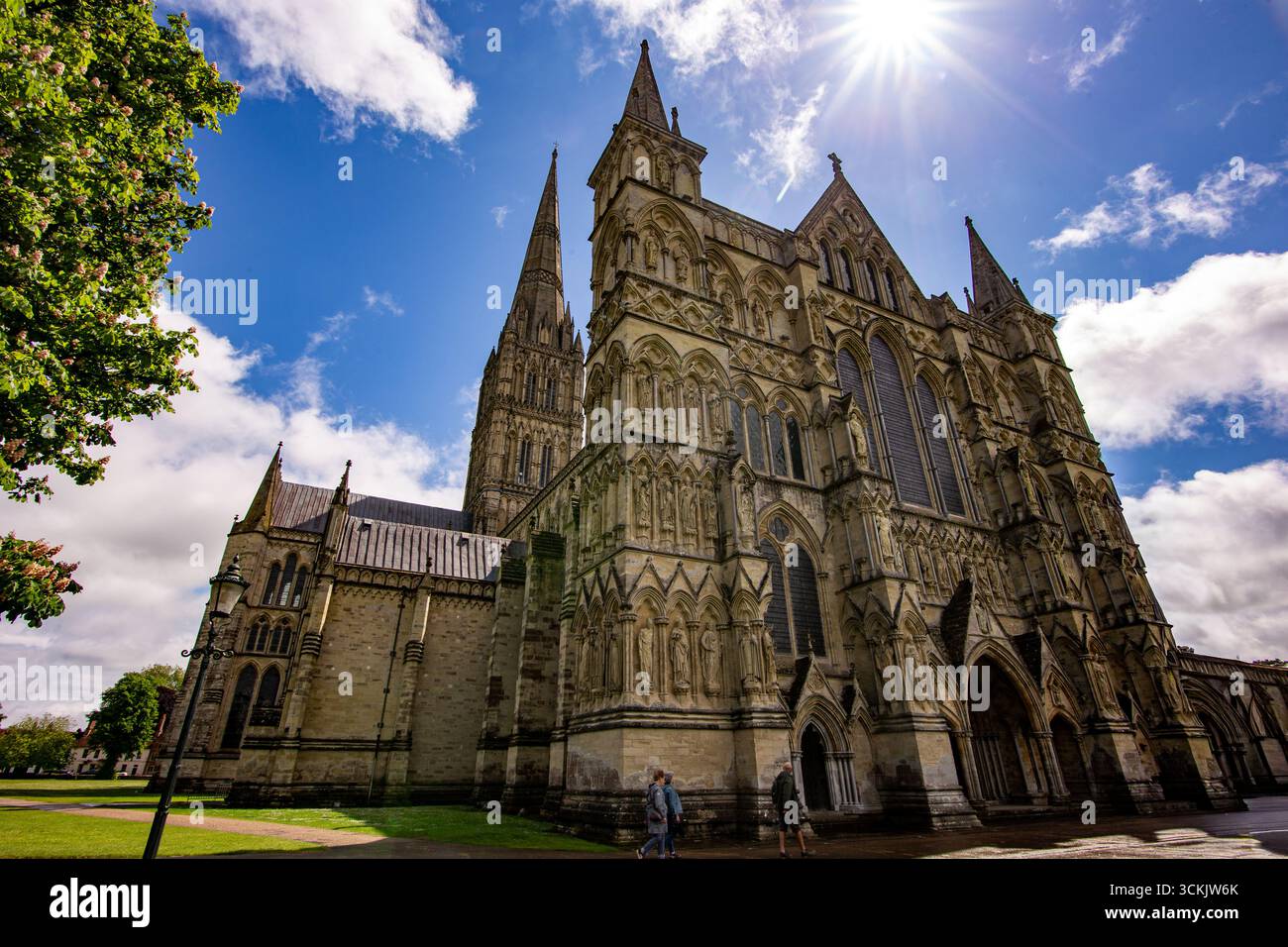 Historische Kathedrale von Salisbury an einem sonnigen Tag mit kunstvoller Architektur, Türmen und einem leuchtend blauen Himmel Stockfoto