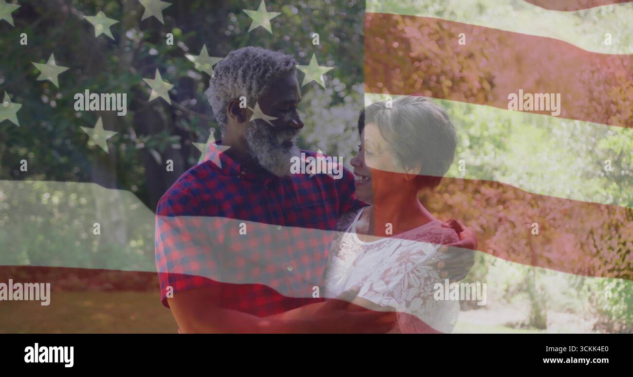 Ein interrassisches Paar, das im sonnigen Garten mit amerikanischer Flagge ein warmes Lächeln teilt Stockfoto