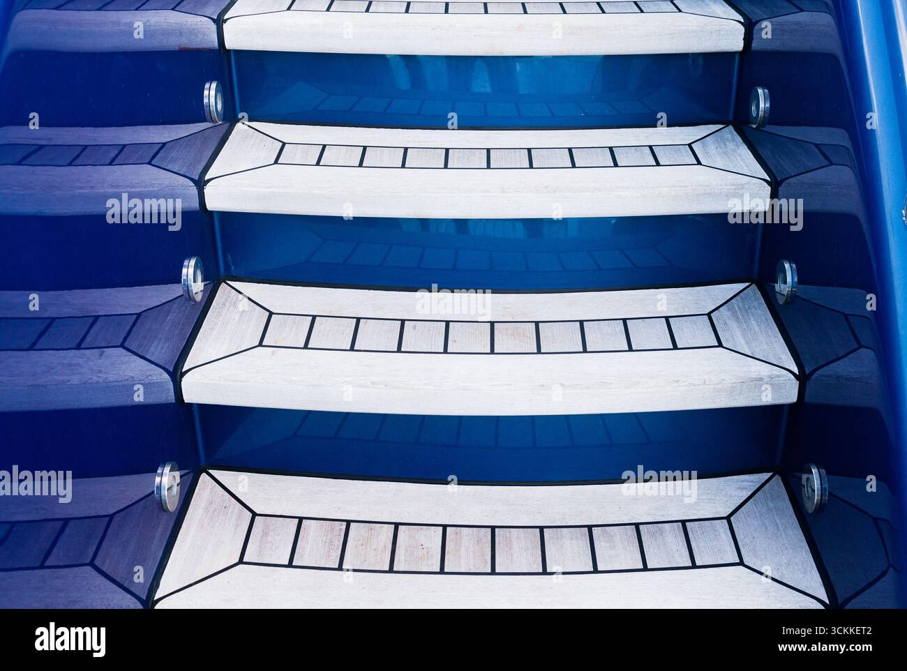 Eine Teakholztreppe führt auf einer modernen Luxusyacht zwischen den Decks nach oben Stockfoto
