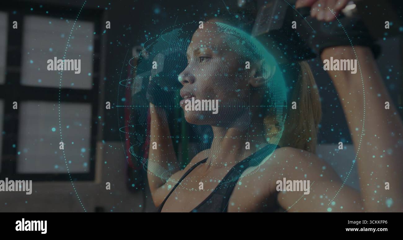 Erwachsene afroamerikanische Frau, die im Fitnessstudio ein Widerstandsband über dem Kopf zieht, mit Globus-Überzug und Handschuhen Stockfoto