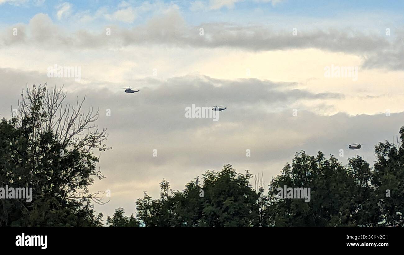 Bischops Stortford, Vereinigtes Königreich – 12.09.2025: Ein Konvoi von US-Militärhubschraubern, einschließlich Marine One und Marine Two VH-60N White Hawks, begleitet von vier CH-47 Chinooks und geführt von einem Eurocopter-Polizeihubschrauber, wird beobachtet, wie er nach dem Abflug vom Flughafen Stansted über Bishops Stortford fliegt. Der koordinierte Formationsflug war Teil eines Übungslaufs zur Vorbereitung des bevorstehenden Staatsbesuchs des ehemaligen US-Präsidenten Donald Trump in Großbritannien. Die Übung hebt die fortgeschrittene Planung und die gemeinsame operative Koordinierung zwischen US-amerikanischen und britischen Sicherheitsdiensten für die Hochrangigen hervor Stockfoto