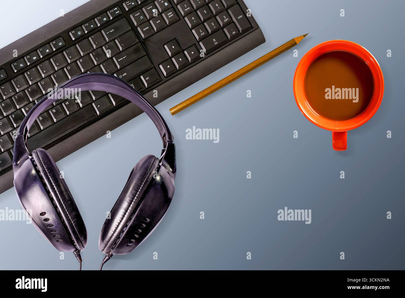 Arbeitsplatz mit Computertastatur, Kaffeetasse, Kopfhörern und Bleistift. Isoliert. Blick von oben. Stockfoto