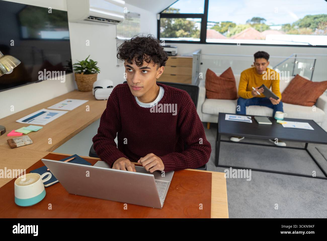 Verschiedene Kollegen arbeiten in einem Loft-Büro mit Laptop, Haftnotizen und Kaffeetassen zusammen Stockfoto