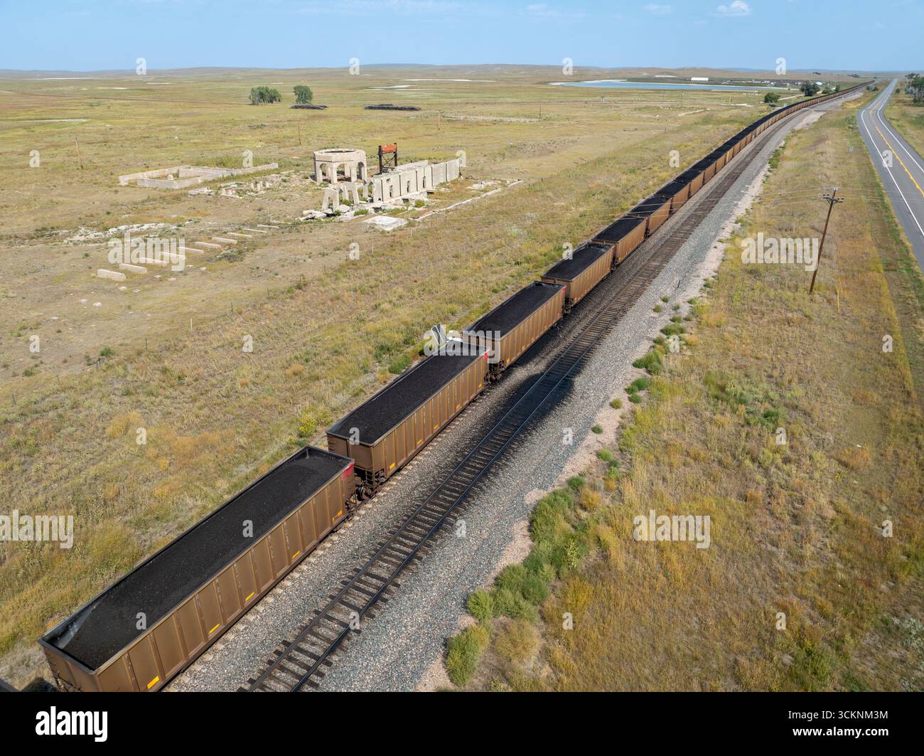 Kohlezug durch Nebraska Sandhills mit Betonruinen einer Kalifabrik in der Nähe von Antioch, Nebraska, aus der Vogelperspektive Stockfoto