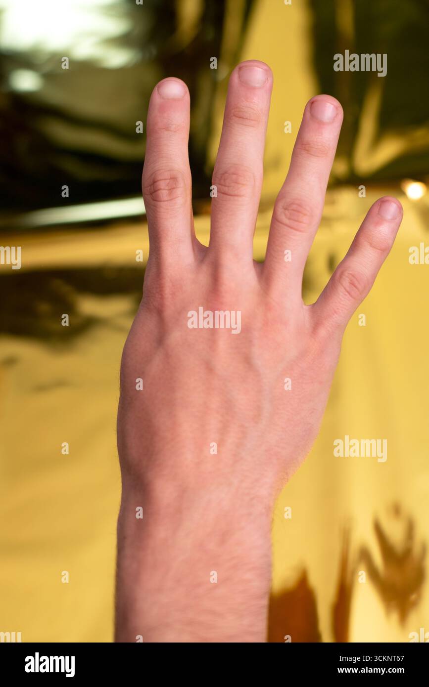 Handarbeit Nummer vier vor goldenem Hintergrund Stockfoto
