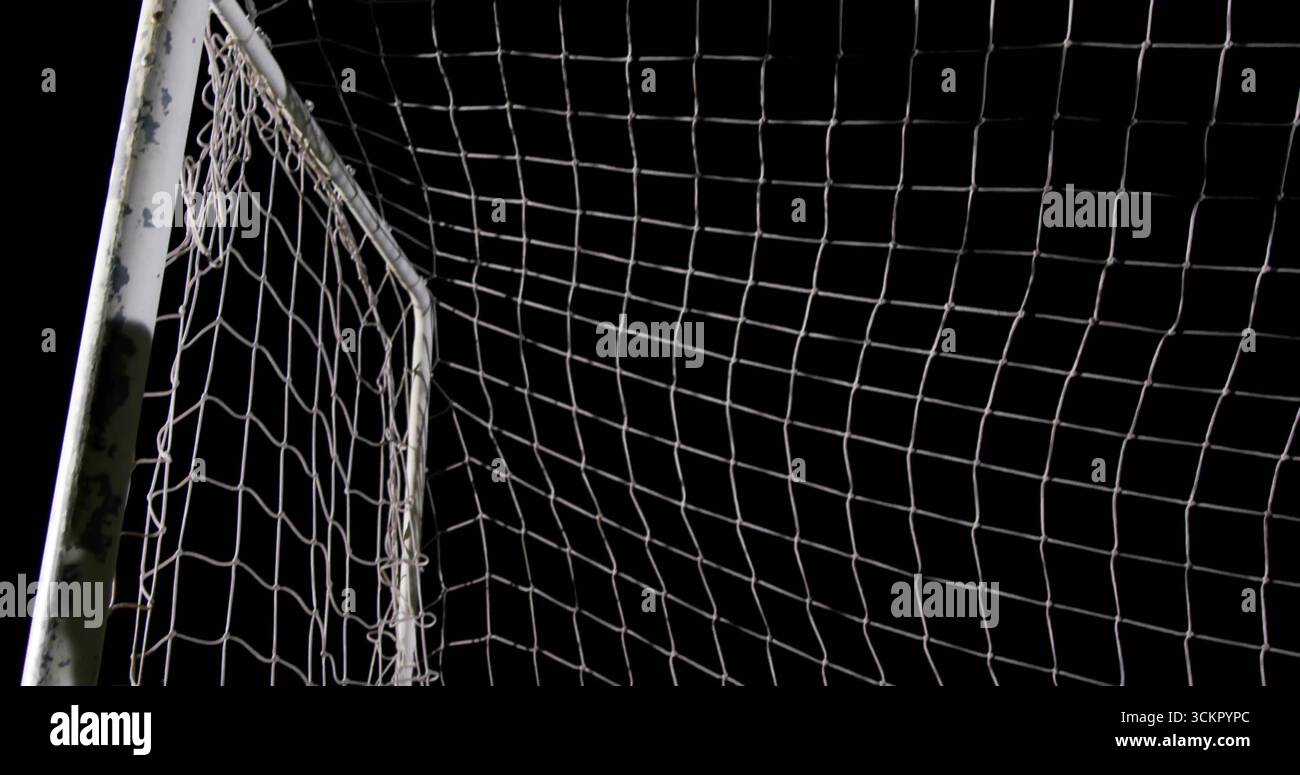Weißer Fußballtorpfosten mit Netz, das nachts auf dem Sportplatz steht, mit abgebrochener Farbe Stockfoto