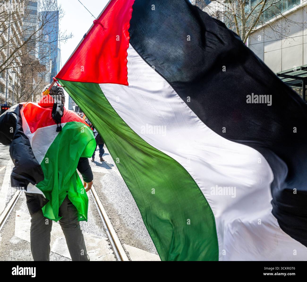 Ein Demonstrant mit palästinensischer Flagge bei einer Demonstration für Palästina in Melbourne, Victoria, Australien. Stockfoto