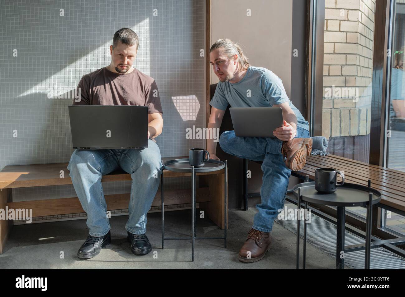 Zwangloses Meeting im modernen Café. Team von Programmierern, die digitalen Code in der Metaverse schreiben und zusammenarbeiten Stockfoto