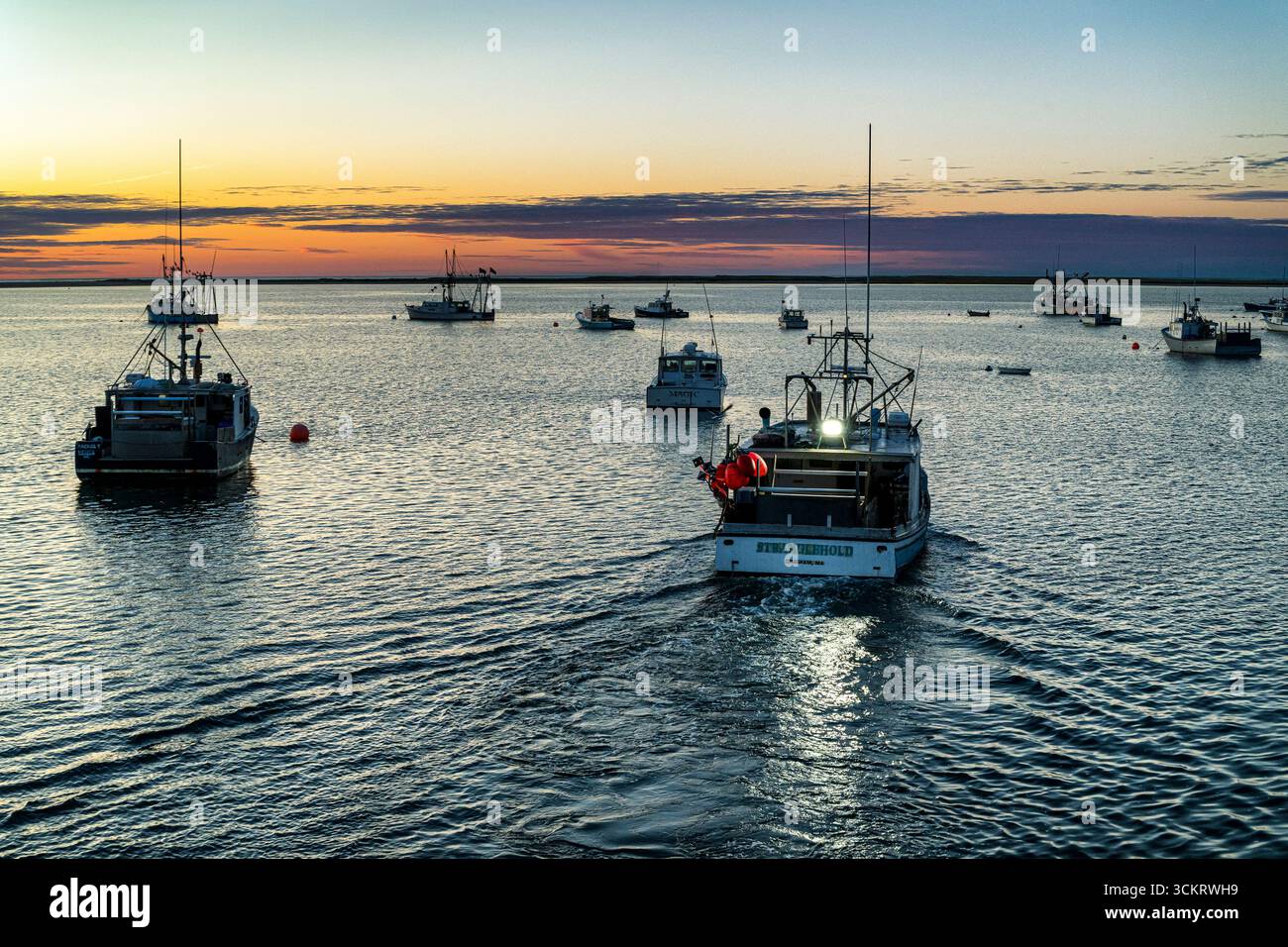 Das Fischerboot legt vor Sonnenaufgang im Hafen von Chatam ab. Stockfoto