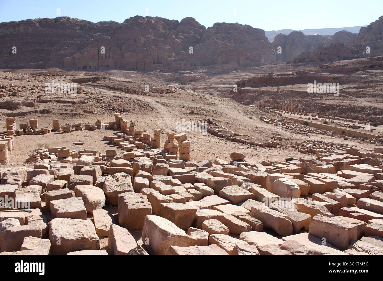Antike Ruinen in der archäologischen Stadt Petra (UNESCO-Stätte), Jordanien, mit Steinblöcken, die über die Wüstenlandschaft verstreut sind. Aufgenommen im November. Stockfoto