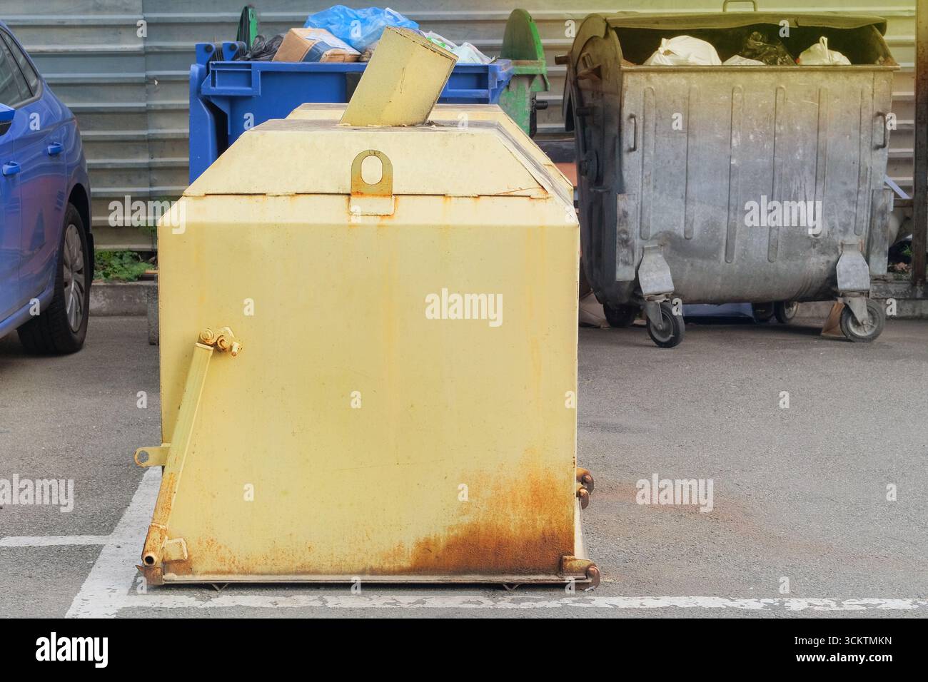 Metallgelber Mülleimer. Müll, Müllhalden, Müllhalde. Müllcontainer sind voll mit Müll. Stockfoto