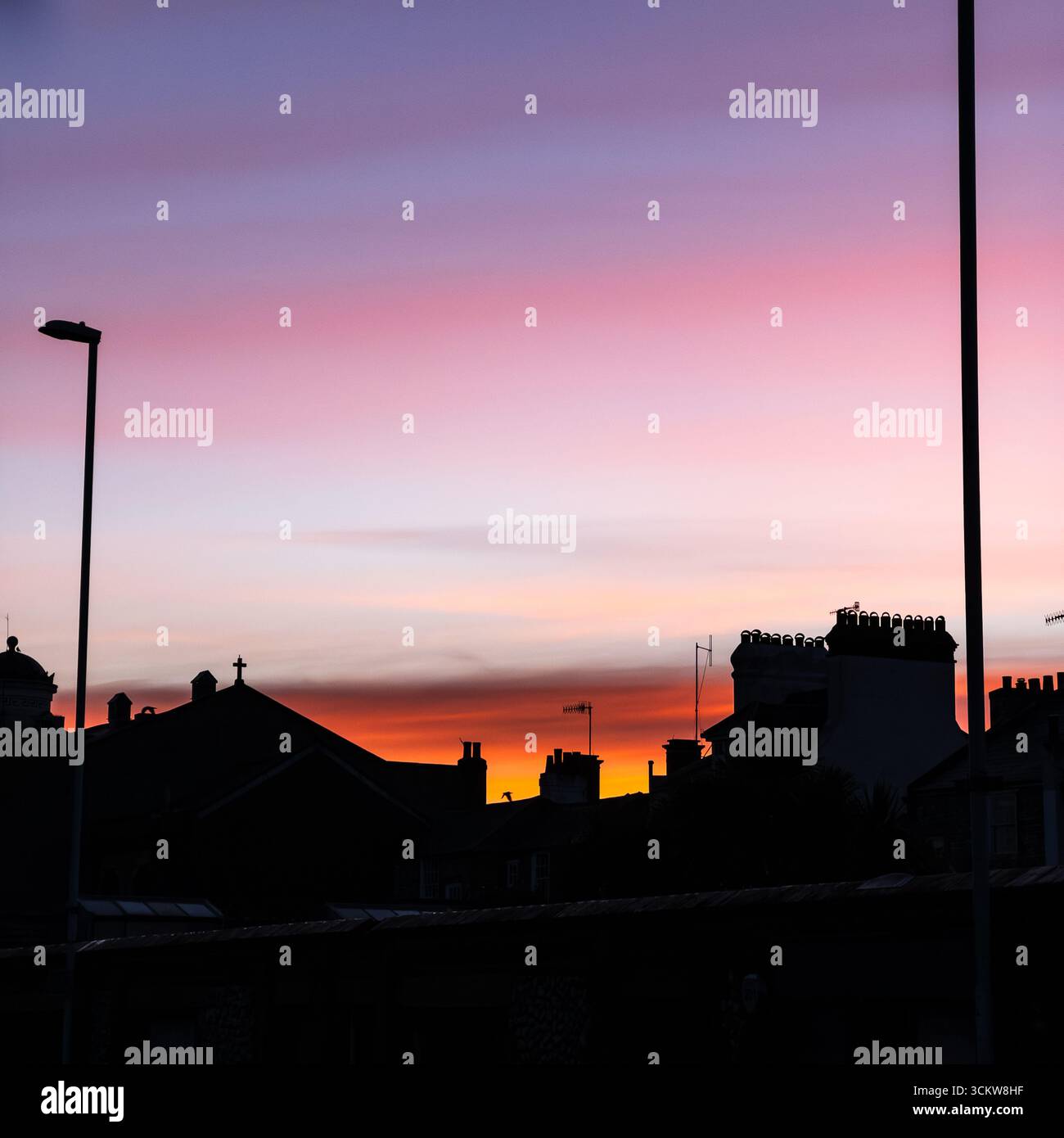 Ein warmer rosafarbener Sonnenaufgang über einer terrasse von Häusern in der Südküste von Worthing - Smartphone-aufgenommenes Stockfoto