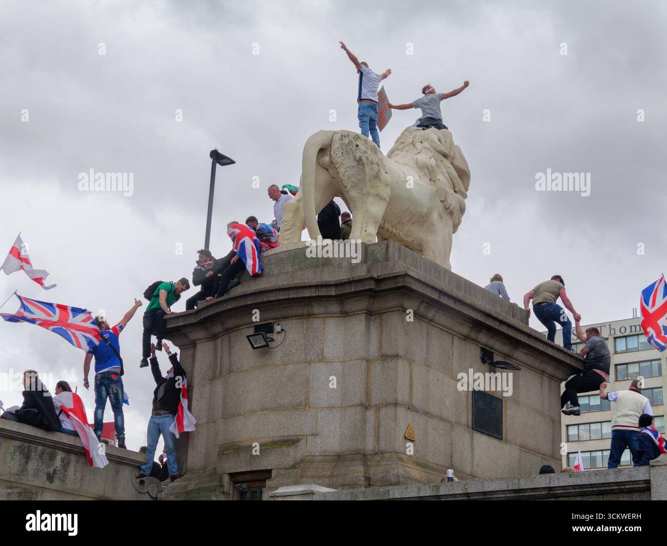 Unite the Kingdom Protest, 13. September 2025, Westminster, London, Großbritannien. Demonstranten mit Union Jack und St George's Flaggen klettern auf dem South Bank Lion auf der Westminster Bridge in Central London bei einem von Tommy Robinson organisierten Protest Stockfoto