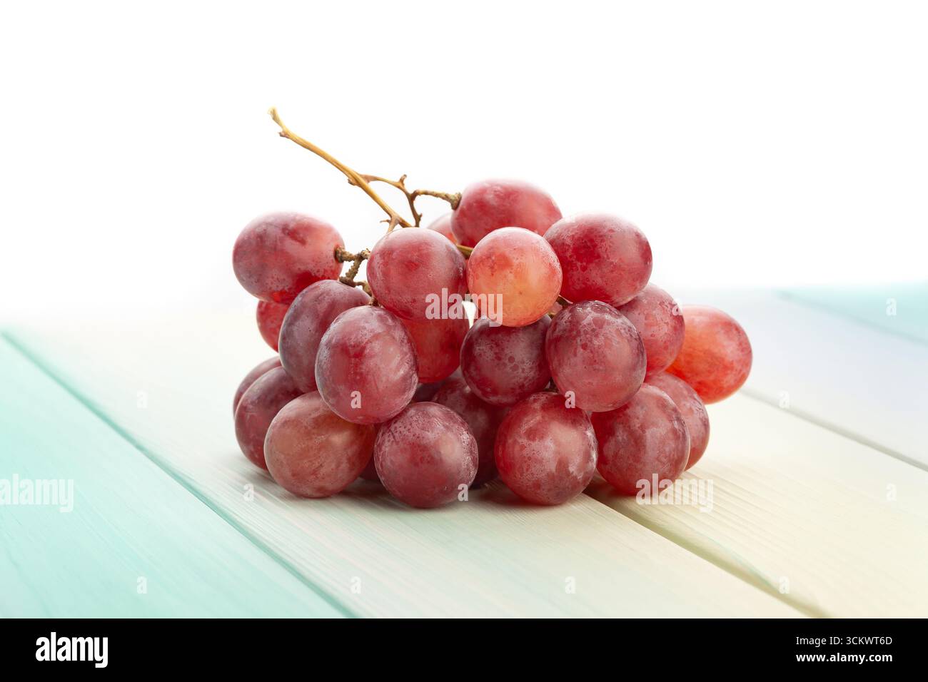 Rote Traube auf Holz Hintergrund auf weiß Stockfoto