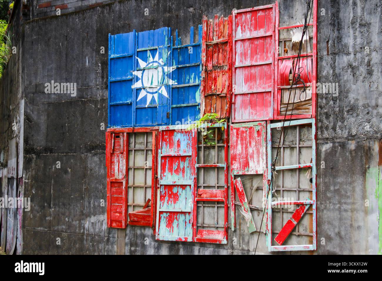 Taoyuan City, Taiwan – 1. Juni 2012: Umgestaltete Fenster bilden eine markante Flagge des ROC auf einer Betonmauer im Xian Guang Military Kindred Village Cultural Pa Stockfoto