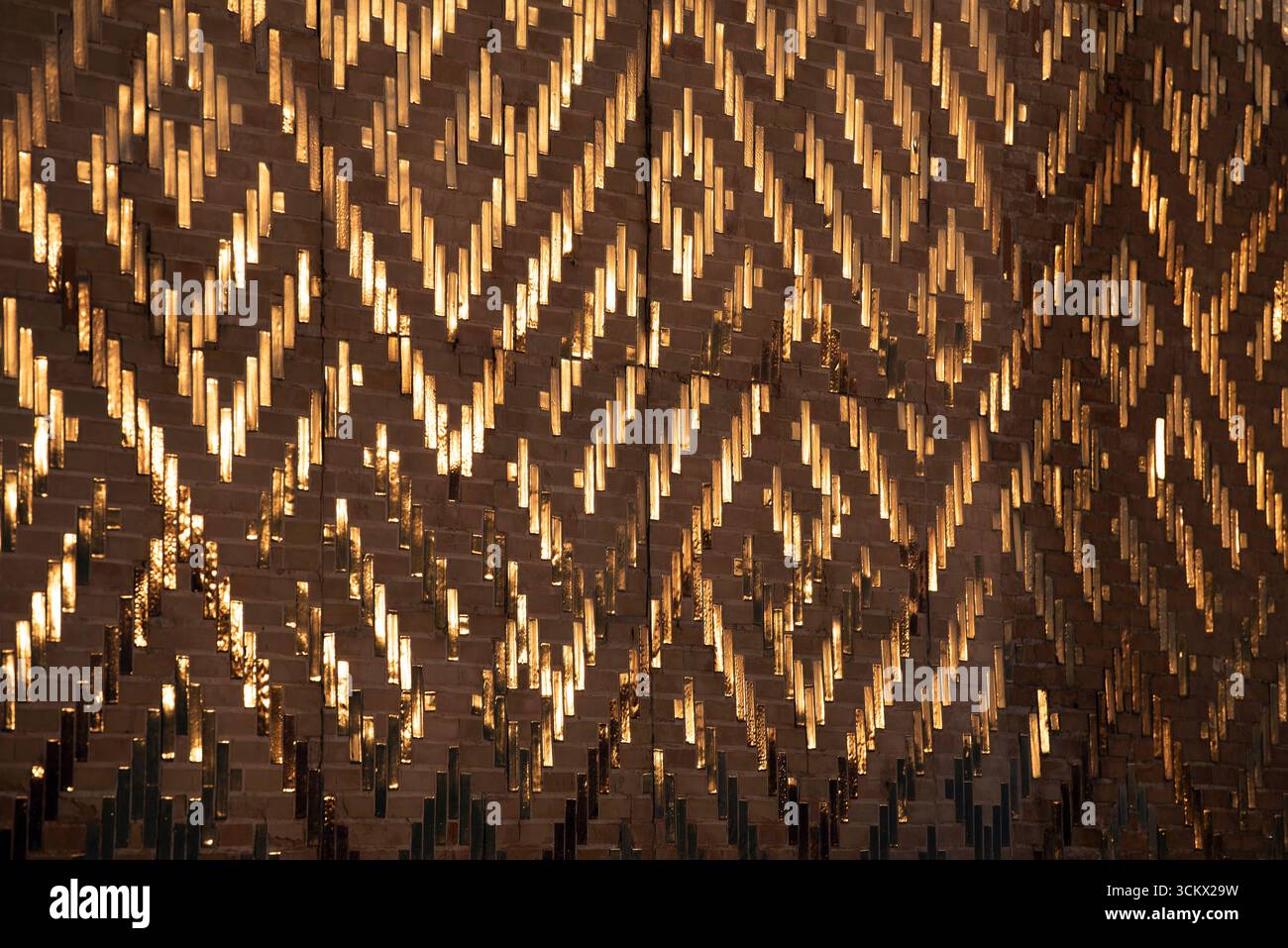 Glasierte Fliesen spiegeln die goldene Stunde der untergehenden Sonne auf der Seite der großen Moschee von Samarkand, Usbekistan im Register wider. Stockfoto