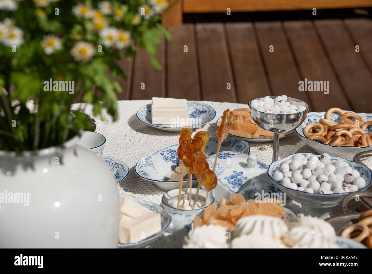 Traditionelle russische Süßigkeiten werden auf feinen Porzellangerichten serviert: Marshmallows, Marmelade, Süßigkeiten und handgemachte Lutscher in Form von Hähnchen Stockfoto