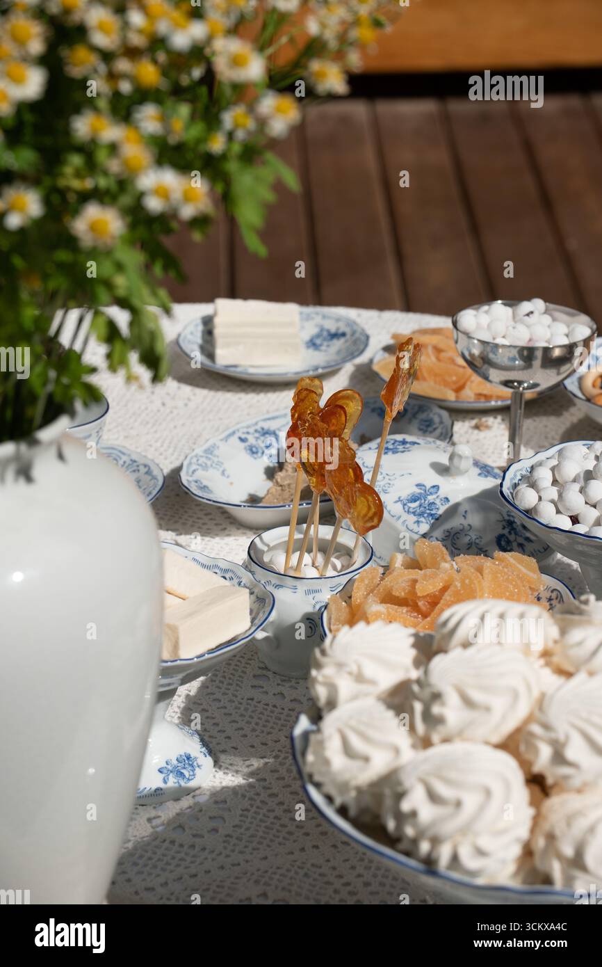 Traditionelle russische Süßigkeiten werden auf feinen Porzellangerichten serviert: Marshmallows, Marmelade, Süßigkeiten und handgemachte Lutscher in Form von Hähnchen Stockfoto