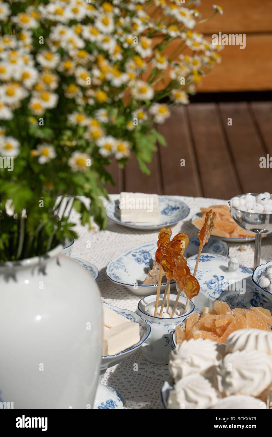Traditionelle russische Süßigkeiten werden auf feinen Porzellangerichten serviert: Marshmallows, Marmelade, Süßigkeiten und handgemachte Lutscher in Form von Hähnchen Stockfoto