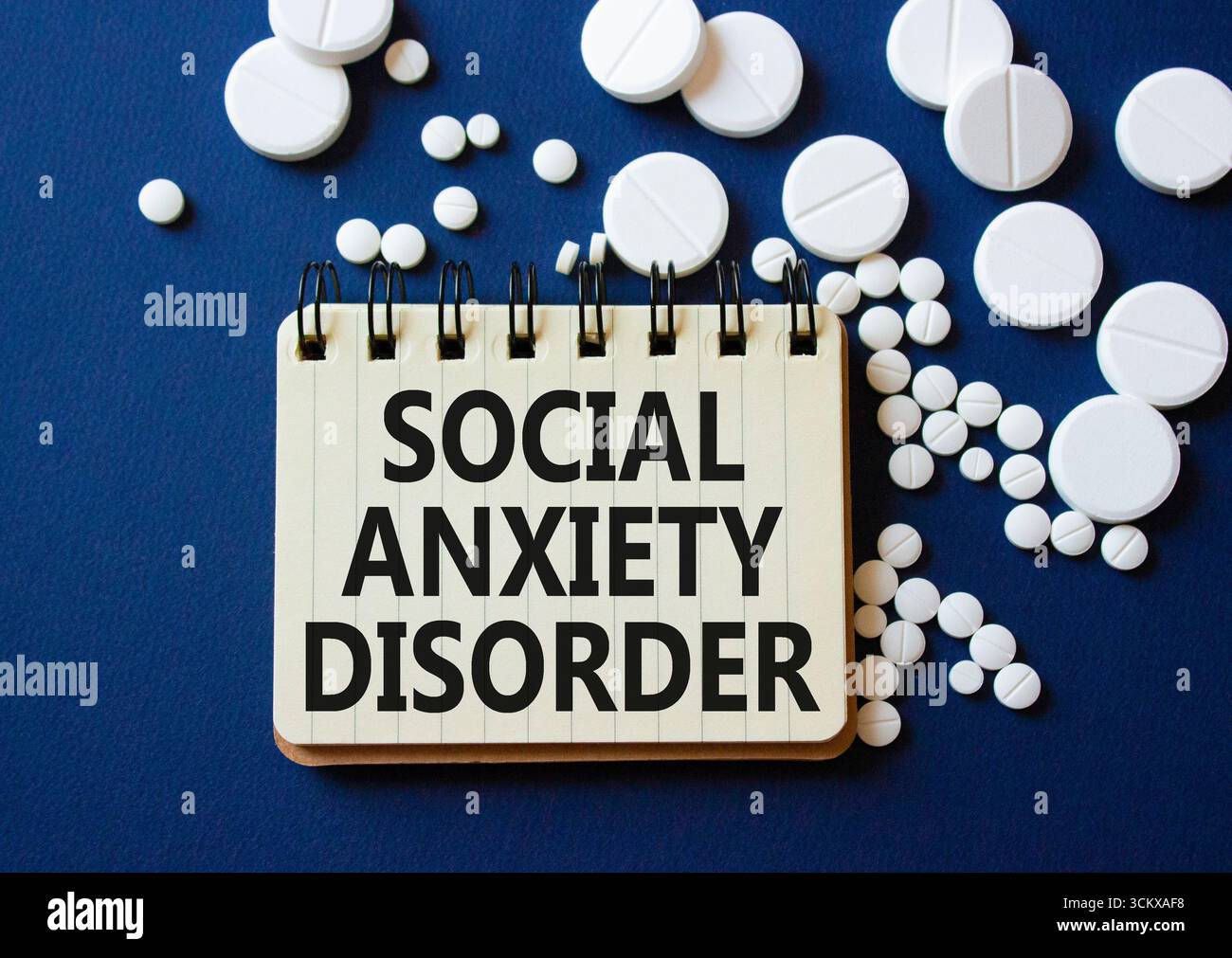 Symbol der sozialen Angststörung. Konzeptworte soziale Angststörung am Notizbuch. Wunderschöner tiefblauer Hintergrund mit Pillen. Gesundheitswesen und Soziales an Stockfoto