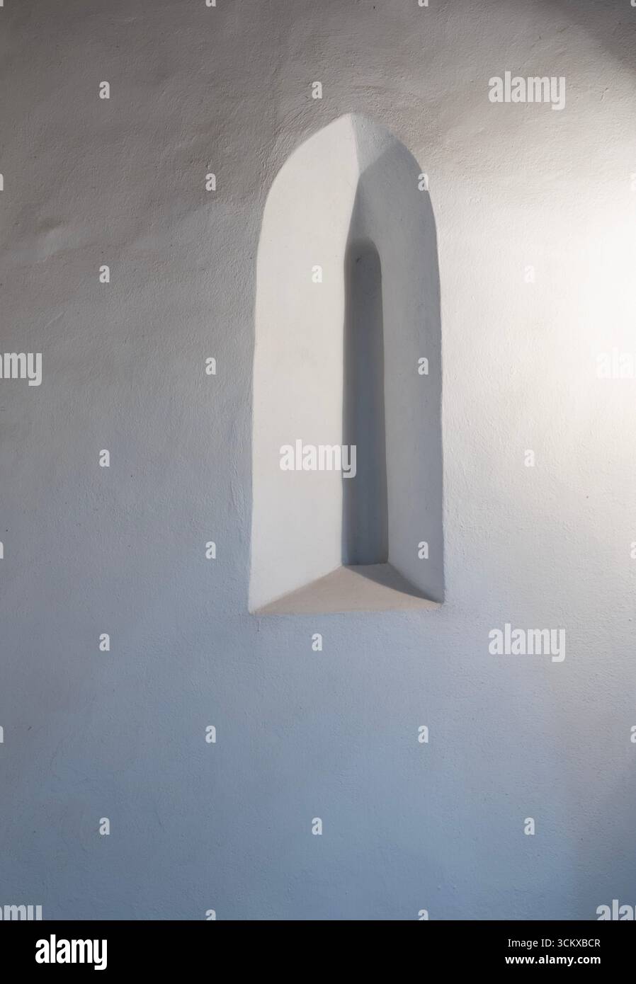 Ruhiges, spirituelles Licht durch das bogenförmige Fenster einer Kathedrale. Abstrakte Details auf einer strukturierten Wand. Ruhige Schönheit in hochauflösender (HR) 80 MP. Stockfoto