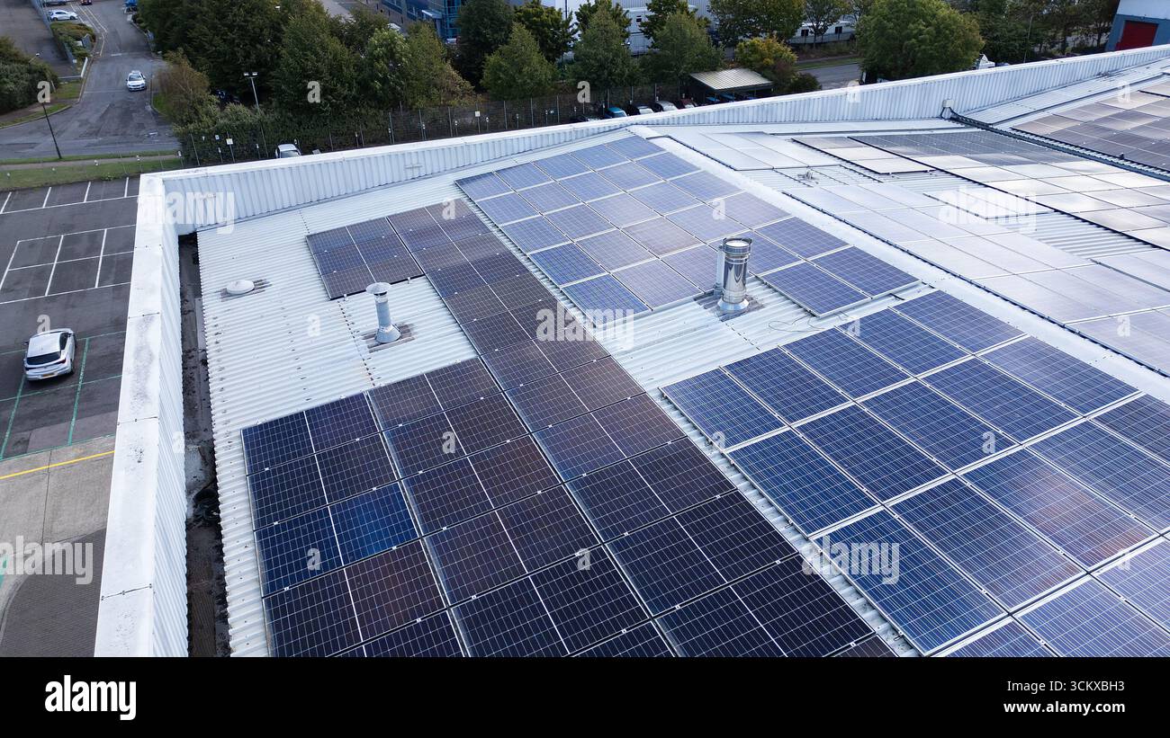 Drohnenansicht von Solarpaneelen, die auf dem Dach eines Lagerhauses in einem Industriepark installiert sind und erneuerbare Energien und nachhaltige Stromerzeugung darstellen. Stockfoto
