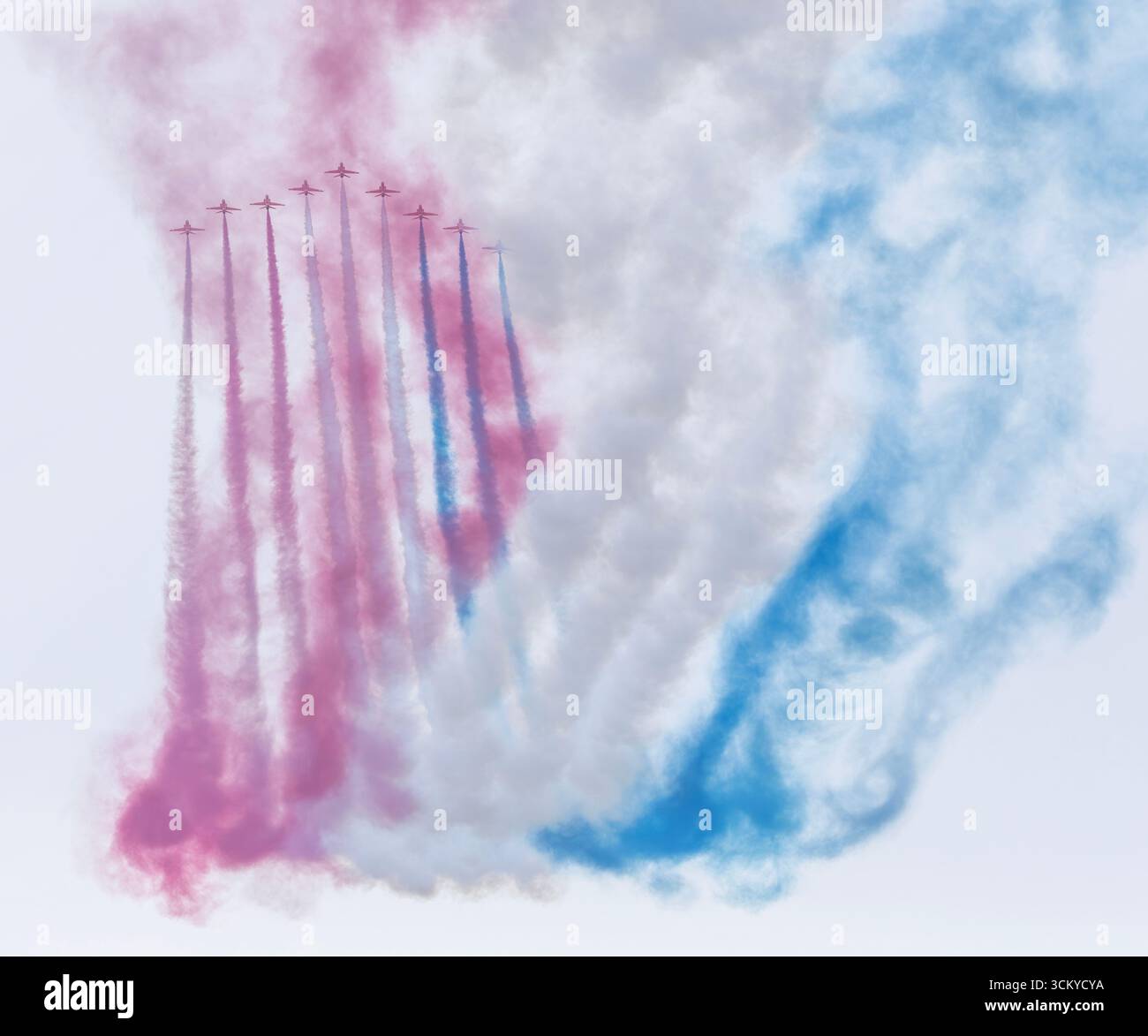 Die Red Arrows, offiziell bekannt als Royal Air Force Aerobatic Team, folgen ihren charakteristischen roten, weißen und blauen Rauchpfaden am Anfang der Th Stockfoto