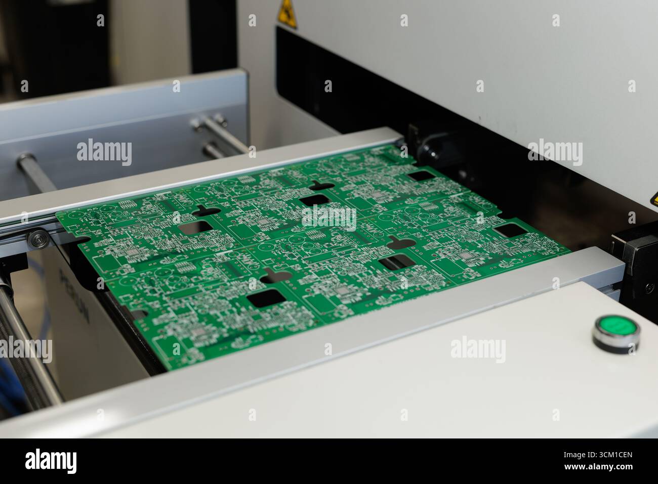 Grüne Leiterplattenplatte wird durch eine Hochgeschwindigkeits-SMD-Linie für die automatisierte Platzierung und Inspektion in einer modernen Elektronikfabrik geführt Stockfoto