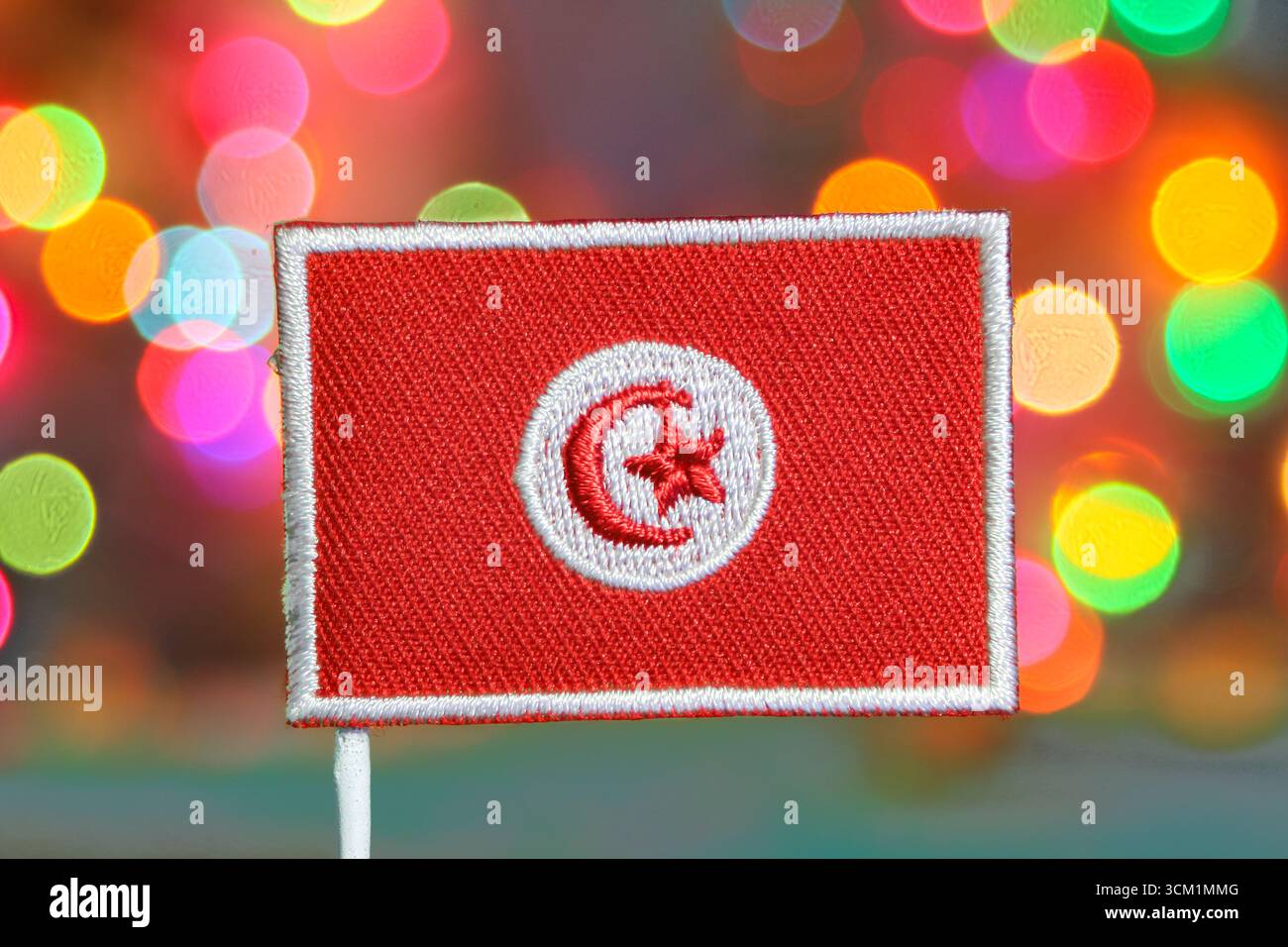 Tunesische Flagge mit bunten Bokeh-Lichtern im Hintergrund, festliches Feuerwerk leuchtet perfekt für Silvesterfeiern. Stockfoto