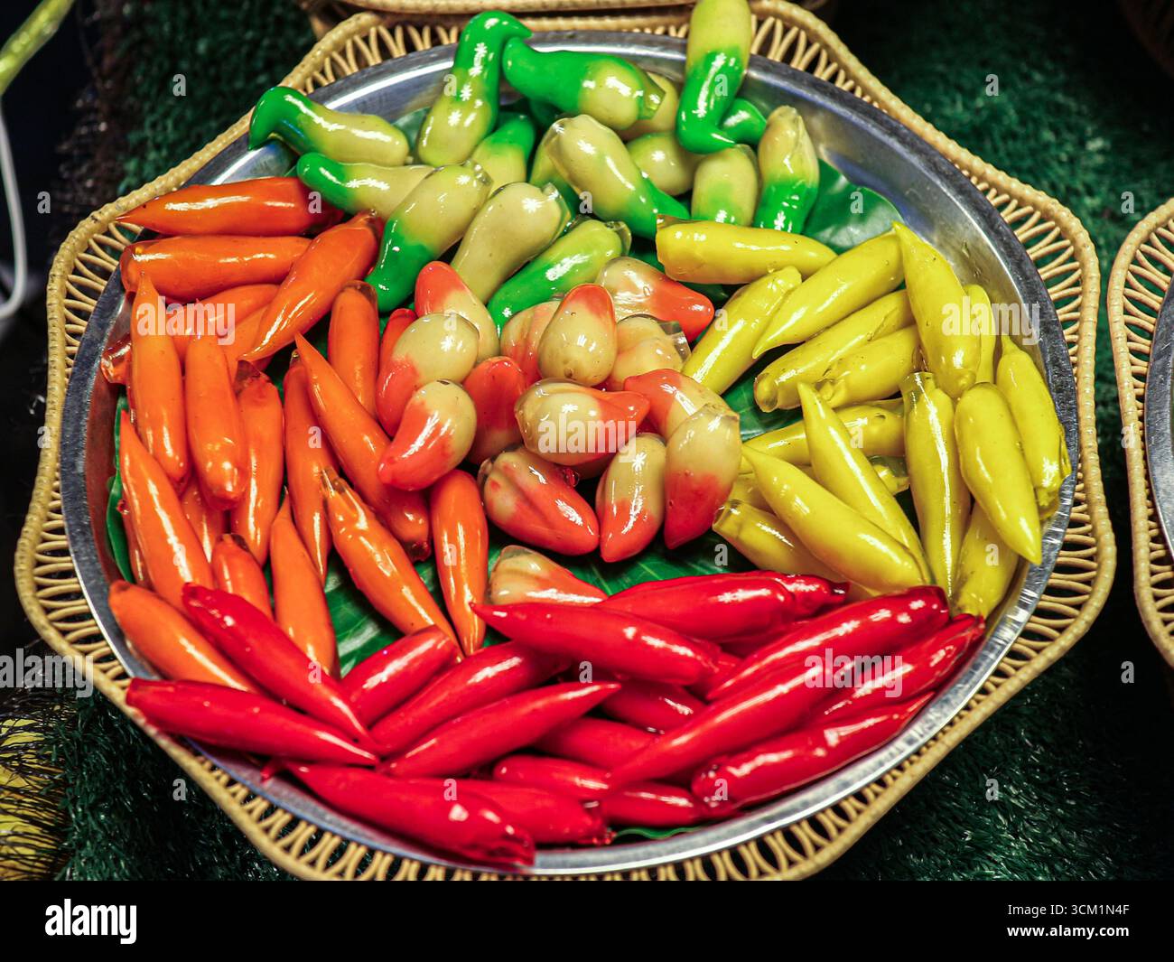 Traditionelles thailändisches Dessert Look Choup, Mungbohnen in Form von farbenfrohem Obst und Gemüse mit glänzender Gelatinebülle, serviert auf Festivals und Veranstaltungen. Stockfoto
