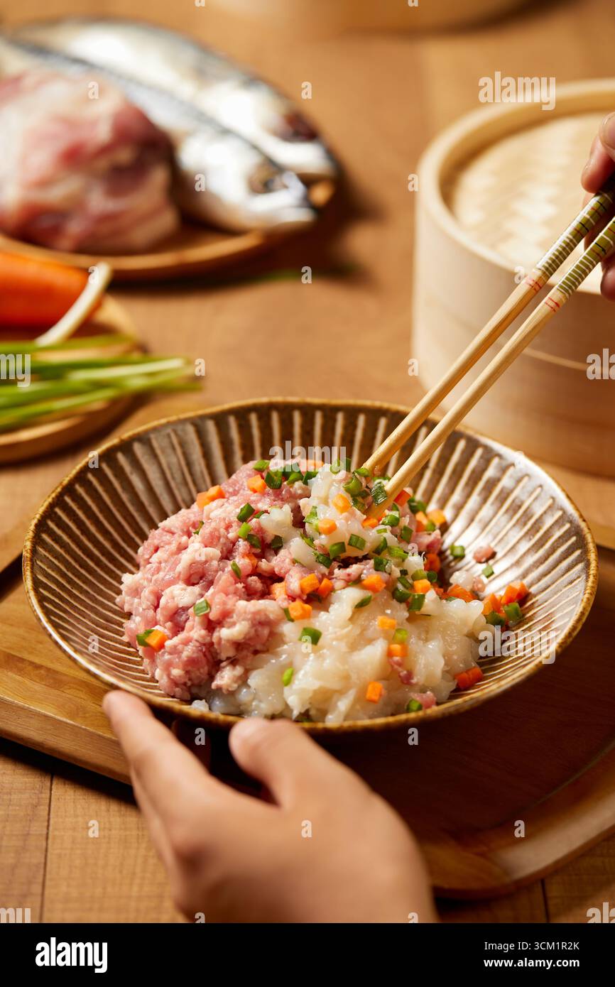 Zubereitung köstlicher asiatischer Knödel Füllung Schweinefleisch, Fisch und Gemüse, neue Bilder von Knödeln Stockfoto