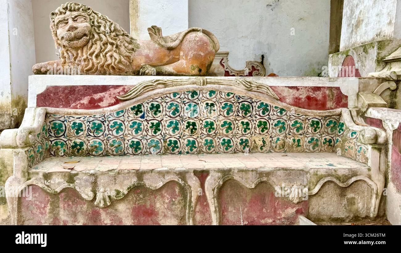 Skulptur eines Löwen über einer Bank mit traditionellen Azulejos-Fliesen im Preta Garden National Palace von Sintra Portugal - Smartphone-aufgenommenes Stockfoto