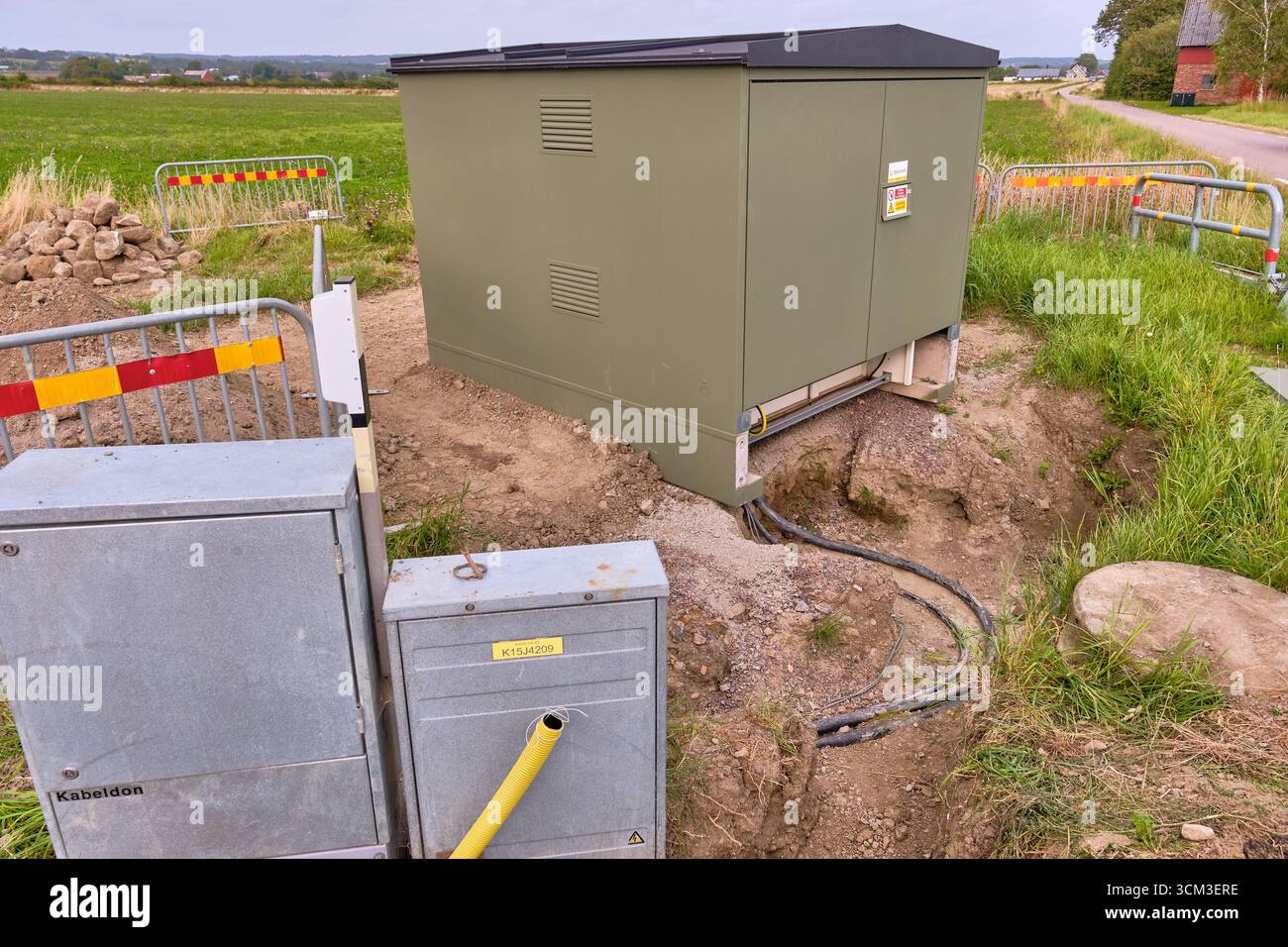 Vistorp, Schweden; 19. August 2023: Neu installierte Trafostation und Hausanschlusskästen mit offenem Erdgraben und Kabel. Stockfoto