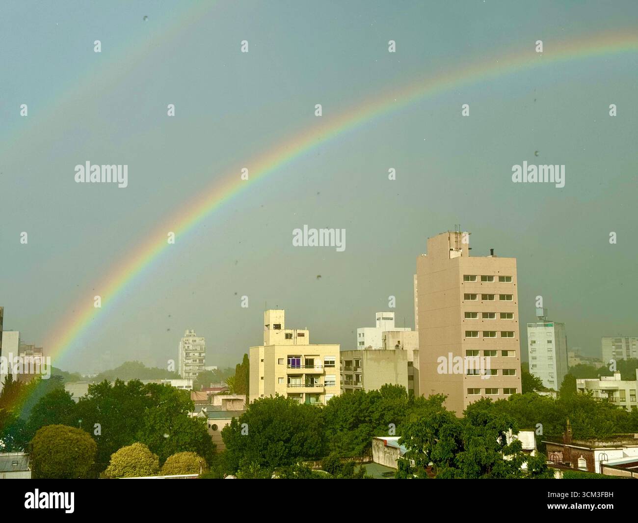 Doppelter Regenbogen über Stadtgebäuden nach Regen, La Plata, Argentinien Stockfoto