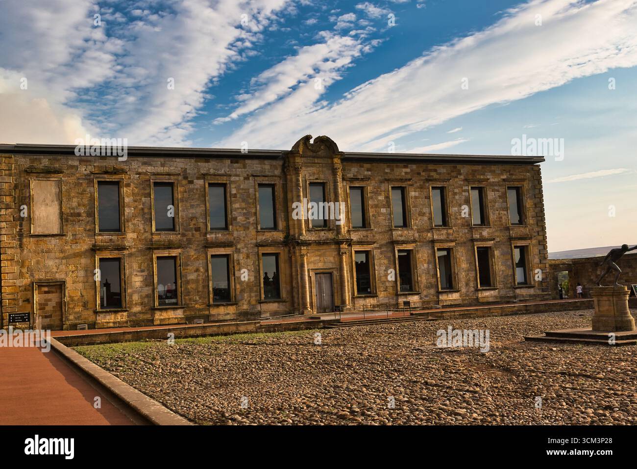 Ein historisches Steingebäude mit symmetrischer Fassade, hohen Fenstern und einem zentralen Eingang vor einem hellblauen Himmel mit schimmernden Wolken in Whitb Stockfoto