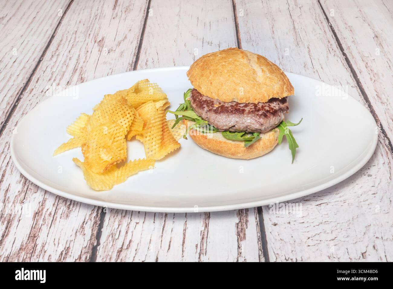 Burger mit schwarzem Brioche-Brötchen, Rindfleisch, geschmolzenem Weißkäse und Speckstreifen für einen eleganten monochromatischen Look. Stockfoto