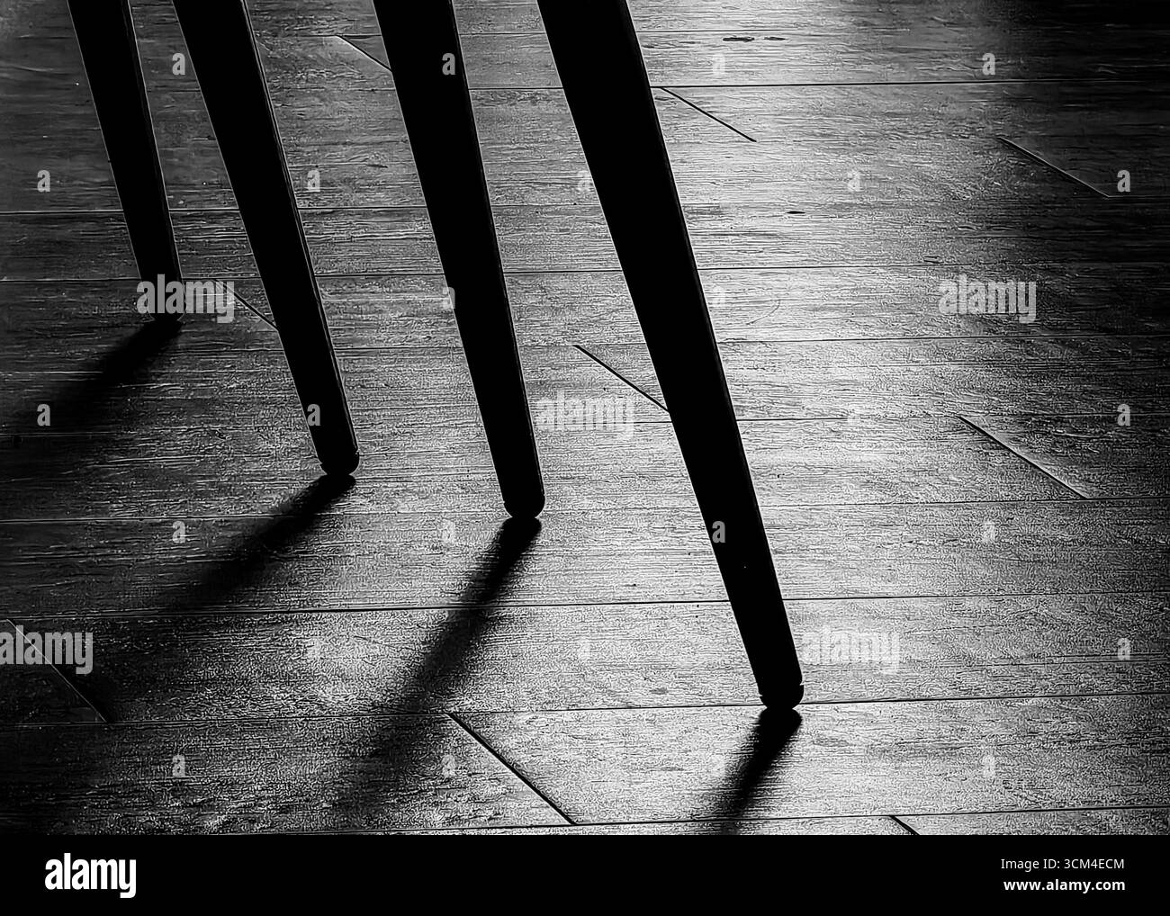 Mystery Legs – Schatten auf gefliestem Boden des Barstuhls. Einfarbige Farbtöne. Stockfoto