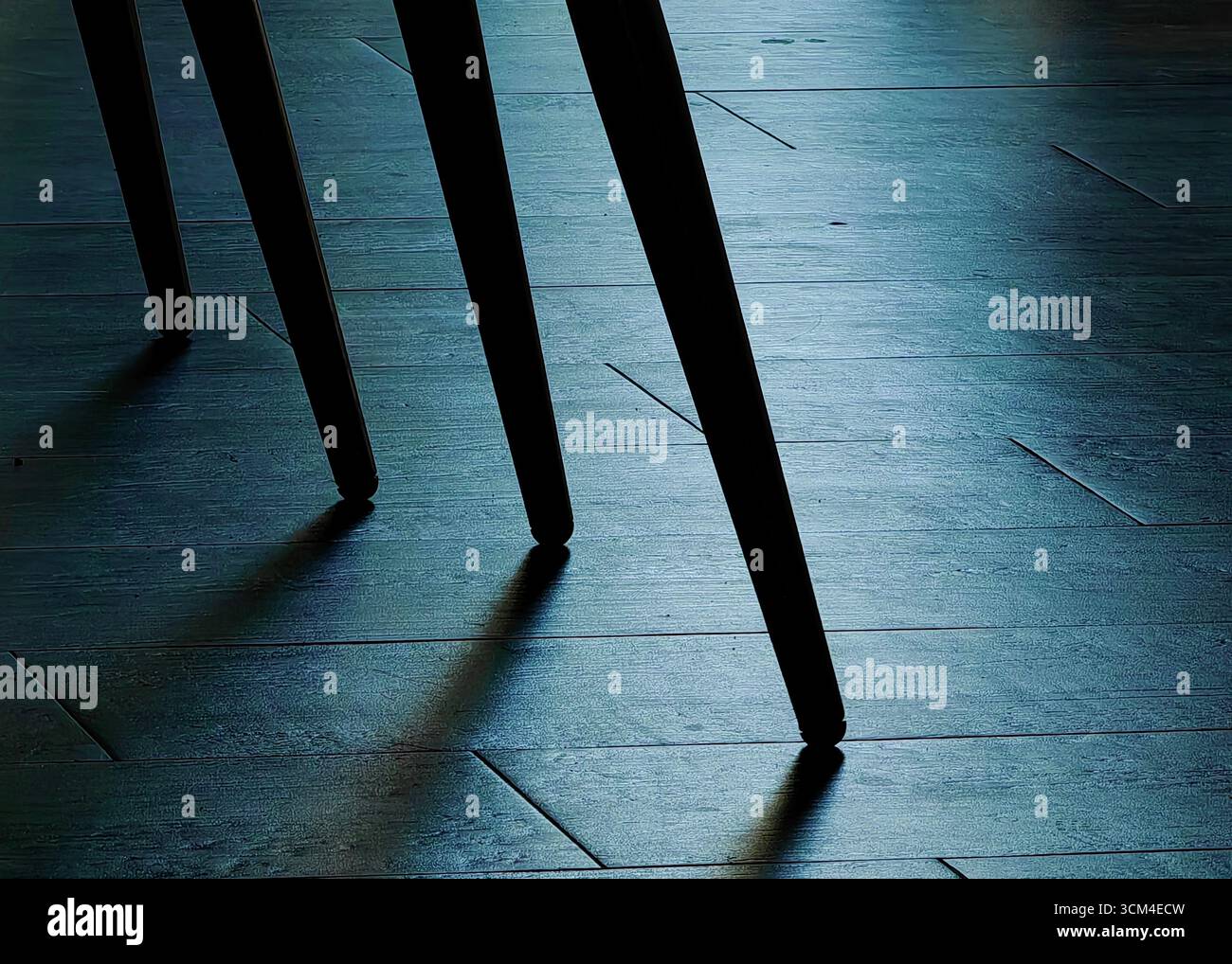 Mystery Legs – Schatten auf gefliestem Boden des Barstuhls Stockfoto