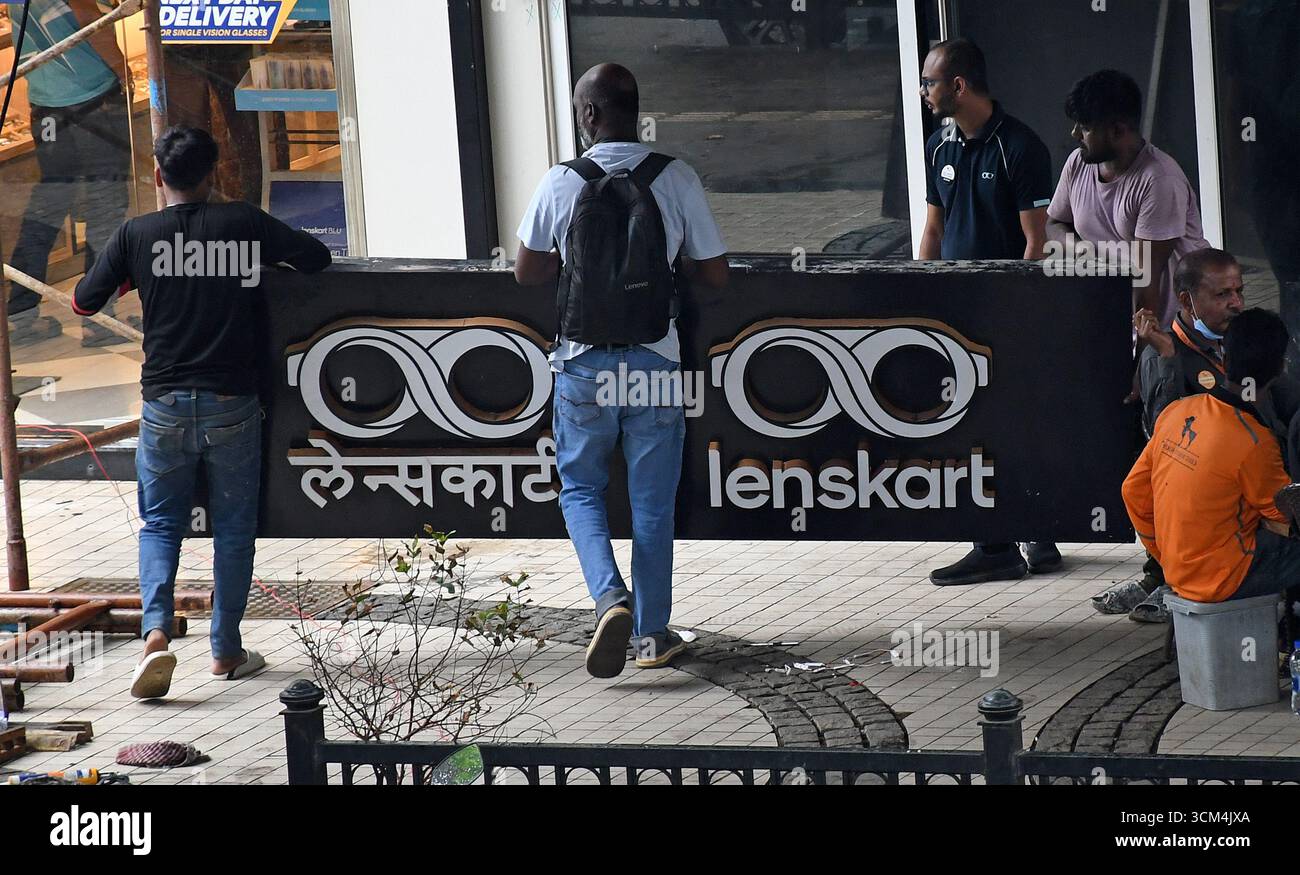 Man sieht Menschen mit einem Schild von Lenskart, nachdem sie es vor ihrem Laden repariert haben. Lenskart ist eine indische multinationale Brillenmarke, die von dem ehemaligen Microsoft-Mitarbeiter Peyush Bansal zusammen mit Amit Chaudhary, Neha Bansal (Ehefrau von Peyush Bansal) und Sumeet Kapahi gegründet wurde. Das Unternehmen verfügt über mehr als 2000 Geschäfte im ganzen Land, die Brillen verkaufen, und auch online über seine Website und mobile App. Stockfoto