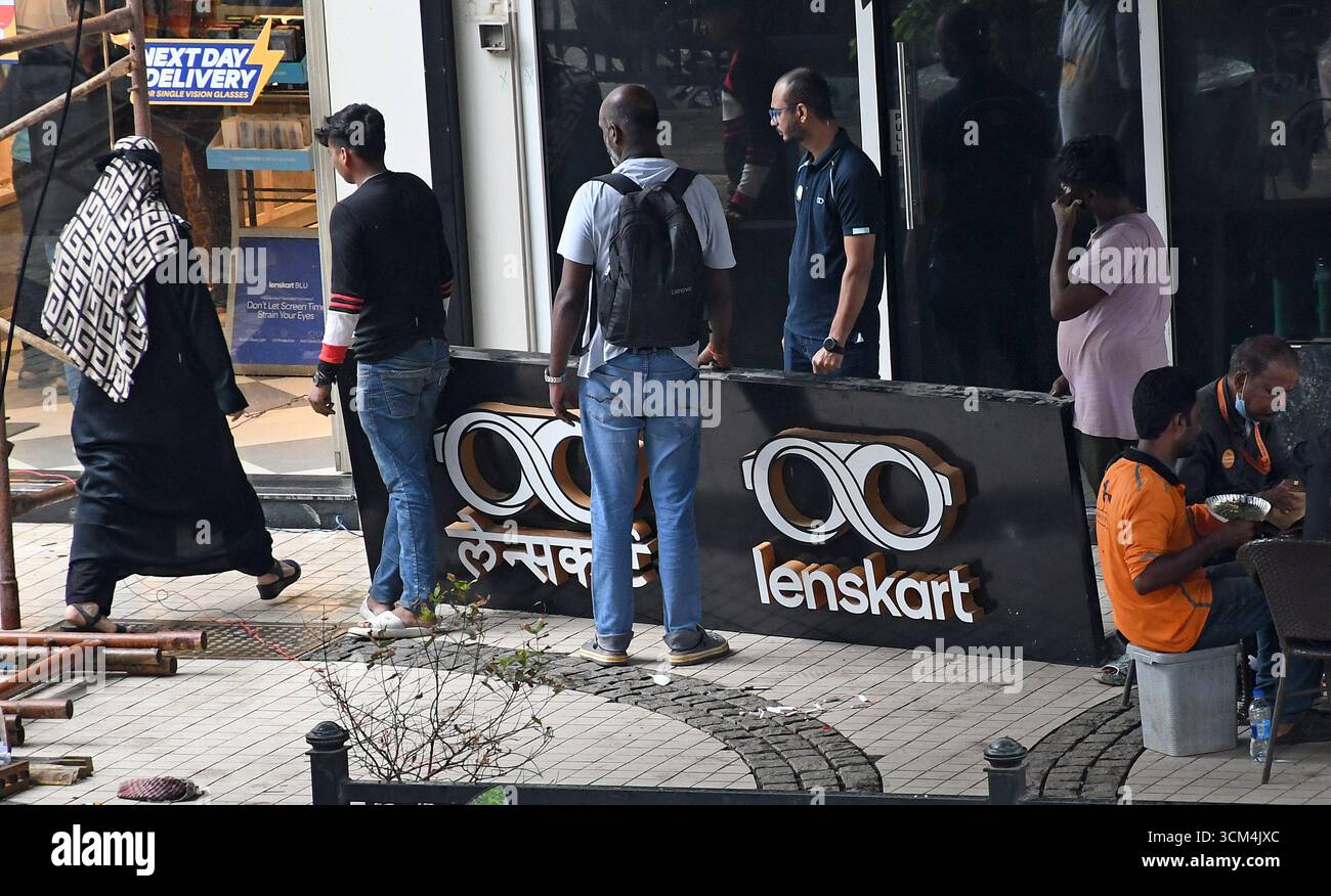 Man sieht Menschen, die in der Nähe der Beschilderung von Lenskart stehen, nachdem sie sie vor ihrem Geschäft repariert haben. Lenskart ist eine indische multinationale Brillenmarke, die von dem ehemaligen Microsoft-Mitarbeiter Peyush Bansal zusammen mit Amit Chaudhary, Neha Bansal (Ehefrau von Peyush Bansal) und Sumeet Kapahi gegründet wurde. Das Unternehmen verfügt über mehr als 2000 Geschäfte im ganzen Land, die Brillen verkaufen, und auch online über seine Website und mobile App. Stockfoto
