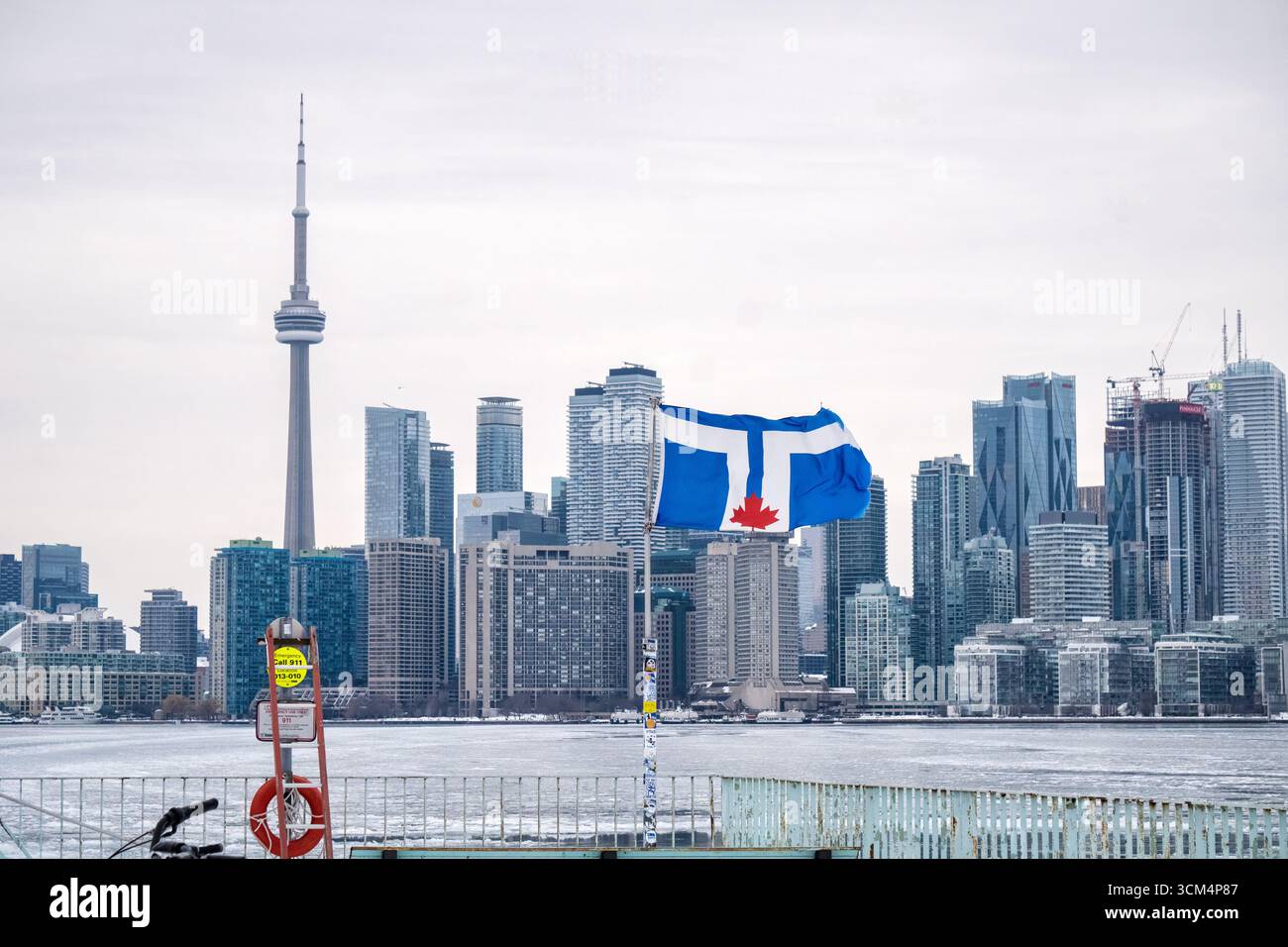Die Skyline von Toronto mit der Stadtflagge auf Wards Island im Vordergrund, CN Tower und anderen Wahrzeichen im Hintergrund Stockfoto